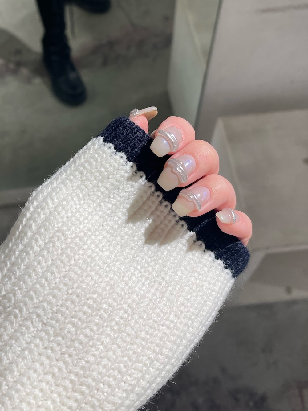 ホワイト系のニット/セーター、ブラック系のスカート、ブラック系のブーツを着用したレディースの冬コーディネートの6枚目の写真