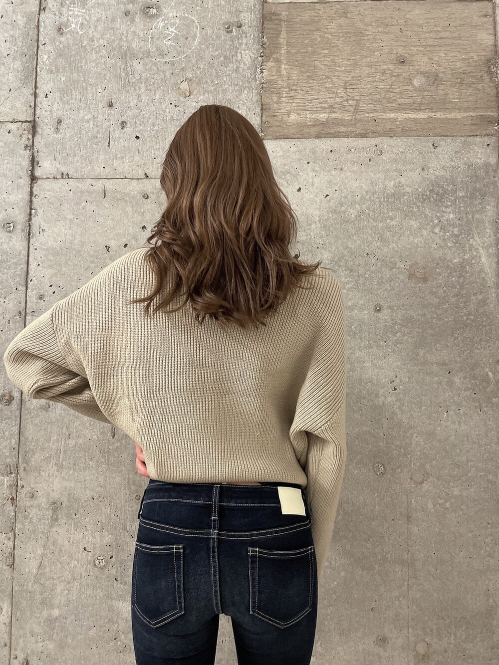 ベージュ系のニット/セーター、ブルー系のデニムパンツ、ブラック系のブーツを着用したレディースの冬コーディネートの4枚目の写真
