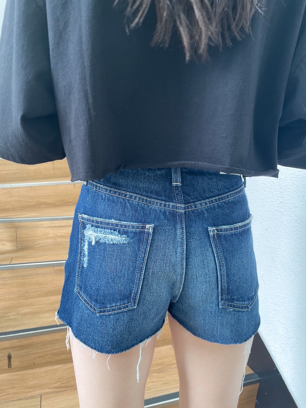 ブラック系のTシャツ/カットソー、ブルー系のデニムパンツ、ブラック系のサンダルを着用したレディースの春コーディネートの6枚目の写真