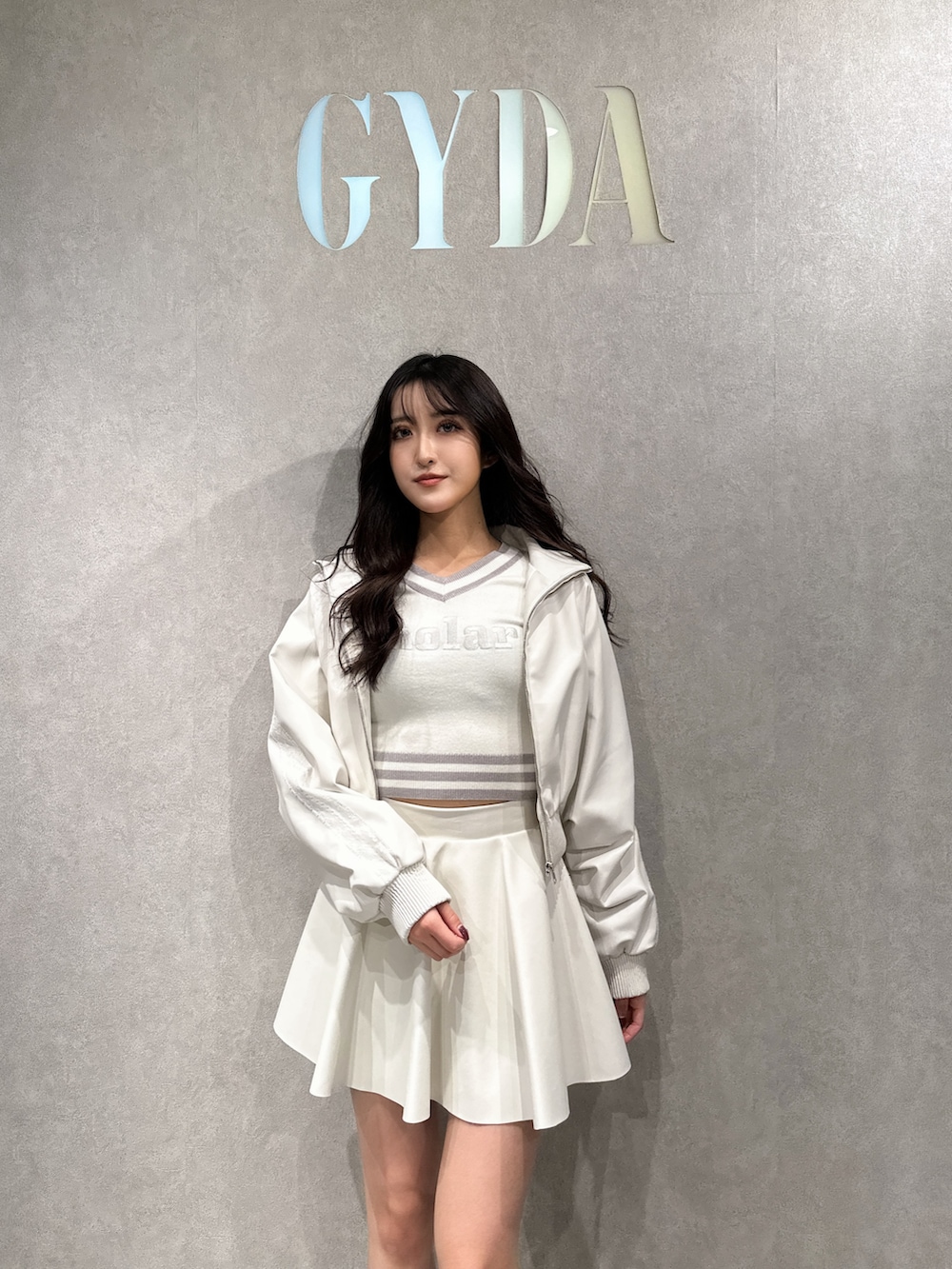 ホワイト系のブルゾン、ホワイト系のニット/セーター、ホワイト系のスカートを着用したレディースの冬コーディネートの3枚目の写真