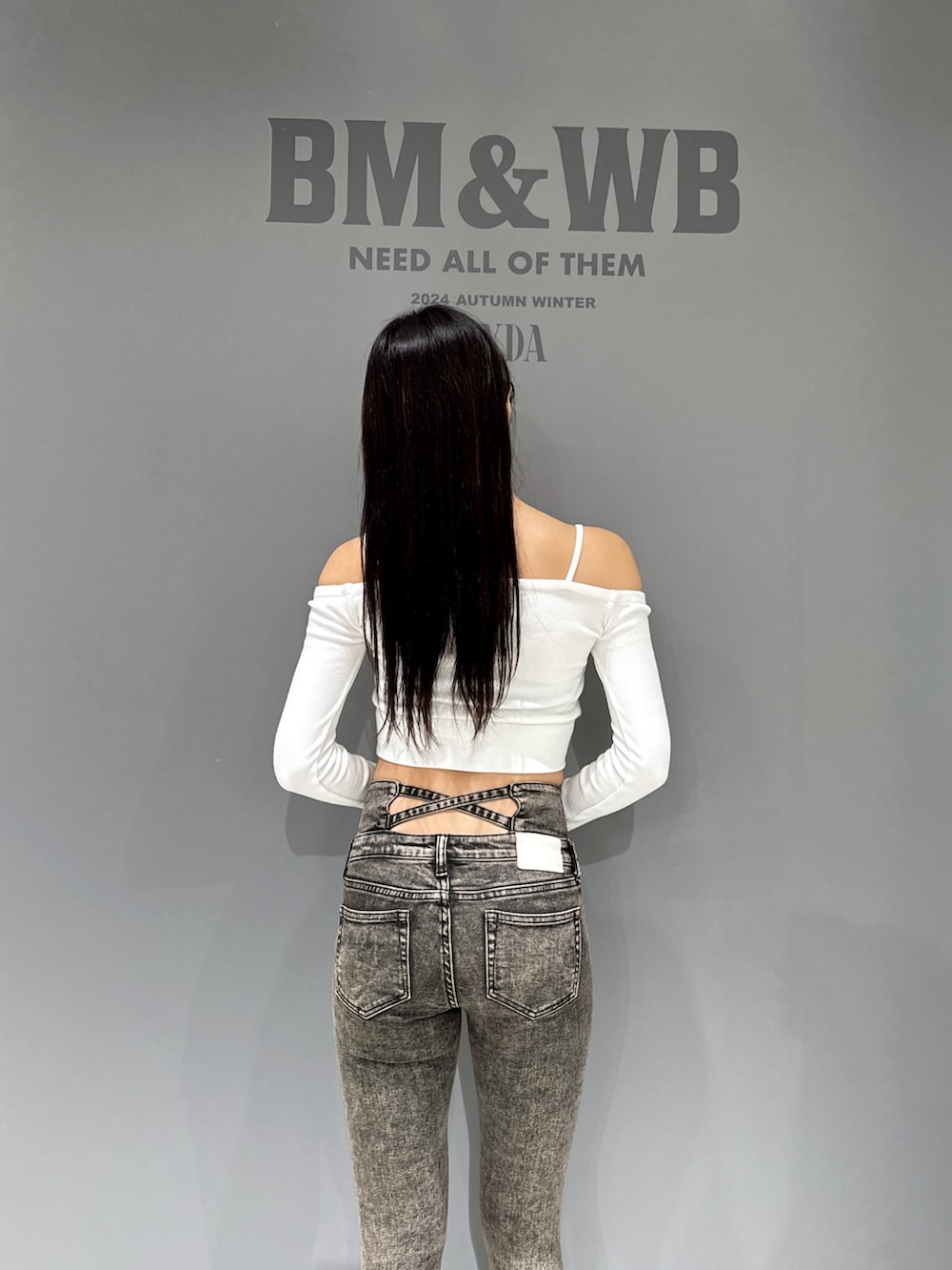 ホワイト系のTシャツ/カットソー、ブラック系のデニムパンツ、ブラック系のブーツを着用したレディースの秋コーディネートの4枚目の写真