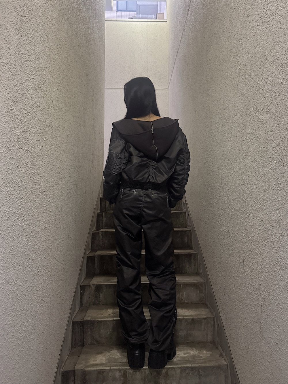 グレー系のブルゾン、ブラック系のブーツ、グレー系のその他パンツを着用したレディースの秋コーディネートの4枚目の写真