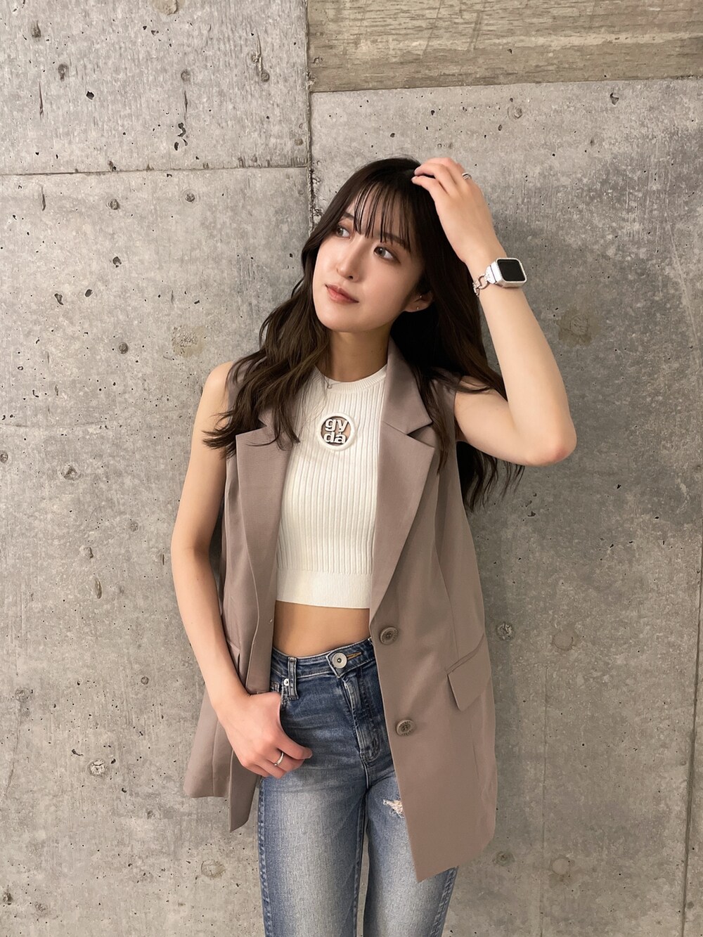 ホワイト系のニット/セーター、ブルー系のデニムパンツ、ホワイト系のパンプスを着用したレディースの春コーディネートの2枚目の写真