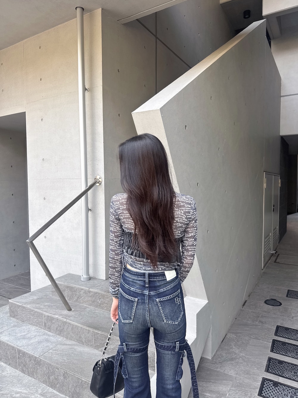 ブラック系のTシャツ/カットソー、ブルー系のデニムパンツ、ブラック系のブーツを着用したレディースの夏コーディネートの4枚目の写真