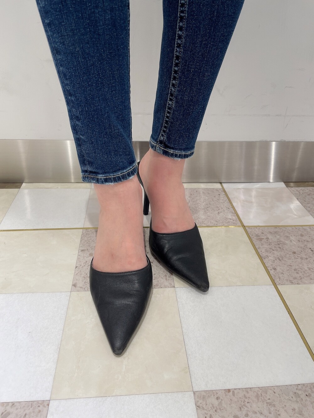 ブラック系のニット/セーター、ブルー系のデニムパンツ、ブラック系のパンプスを着用したレディースの秋コーディネートの6枚目の写真