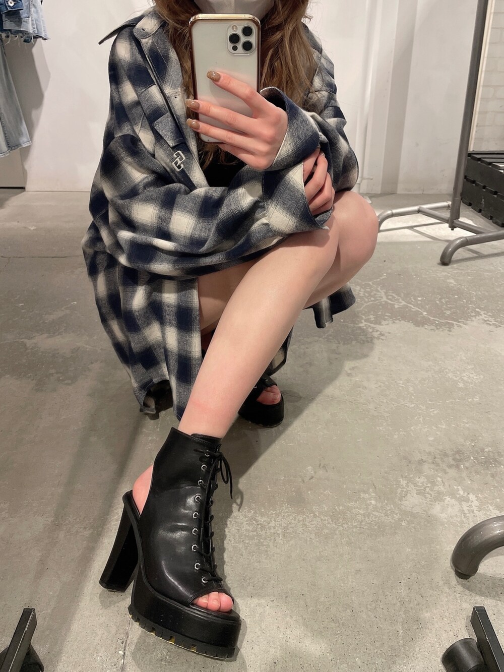 ブラック系のブーツ、ブラック系のキャミソール、ブルー系のデニムパンツを着用したレディースの春コーディネートの7枚目の写真