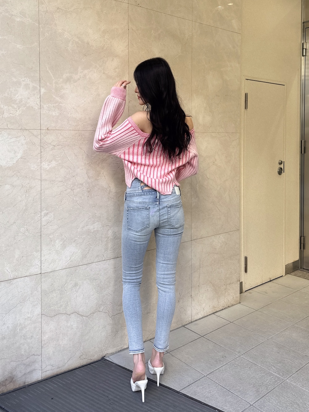 ホワイト系のパンプス、ブルー系のデニムパンツ、ピンク系のニット/セーターを着用したレディースの冬コーディネートの3枚目の写真