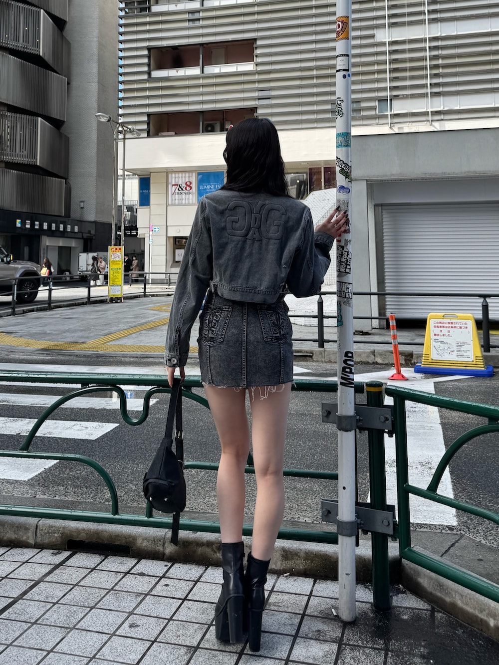 ブラック系のワンピース、ブラック系のデニムジャケット、ブラック系のハンドバッグを着用したレディースの春コーディネートの3枚目の写真