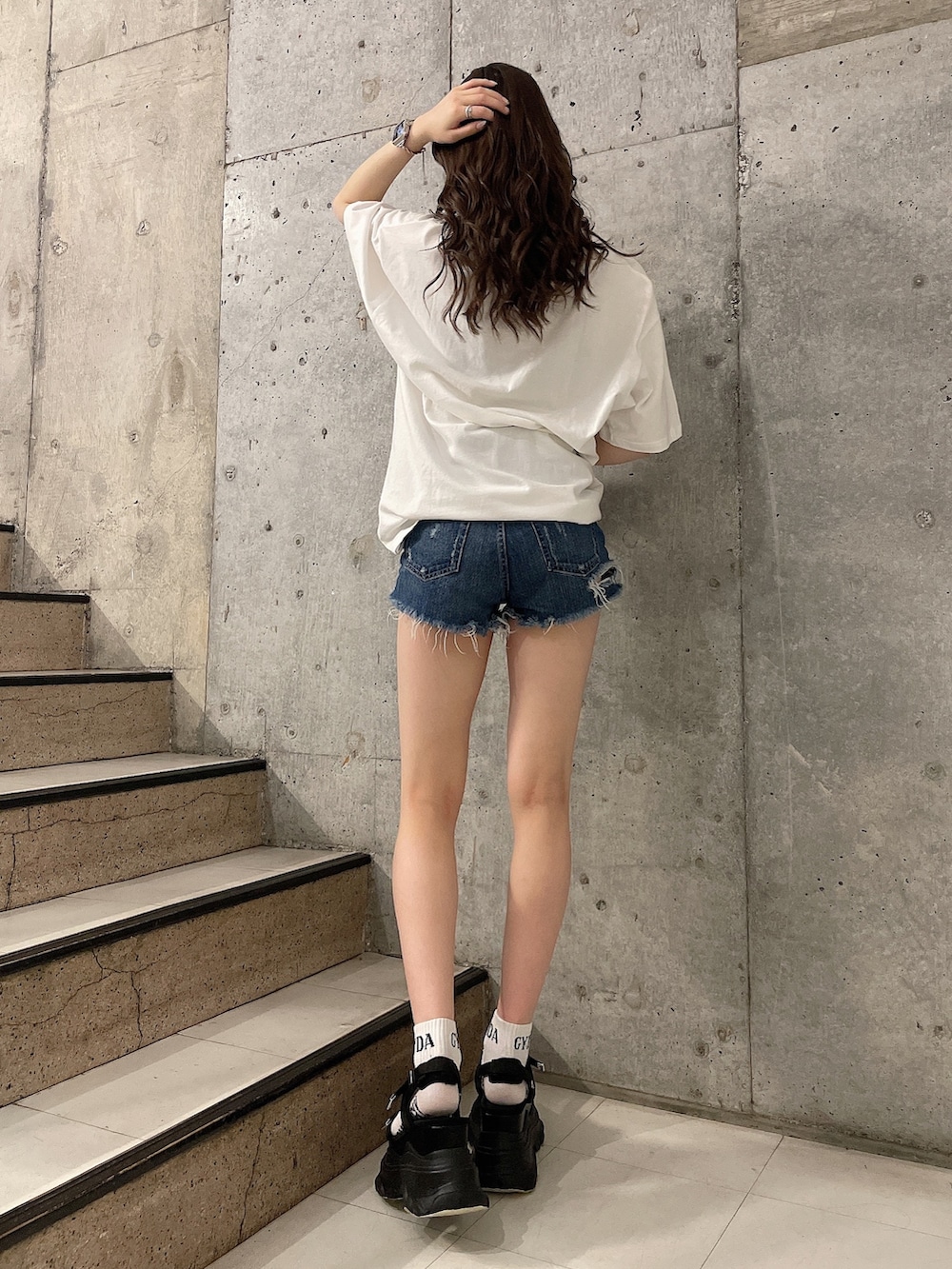ホワイト系のTシャツ/カットソー、ブルー系のデニムパンツ、ブラック系のサンダルを着用したレディースの春コーディネートの3枚目の写真