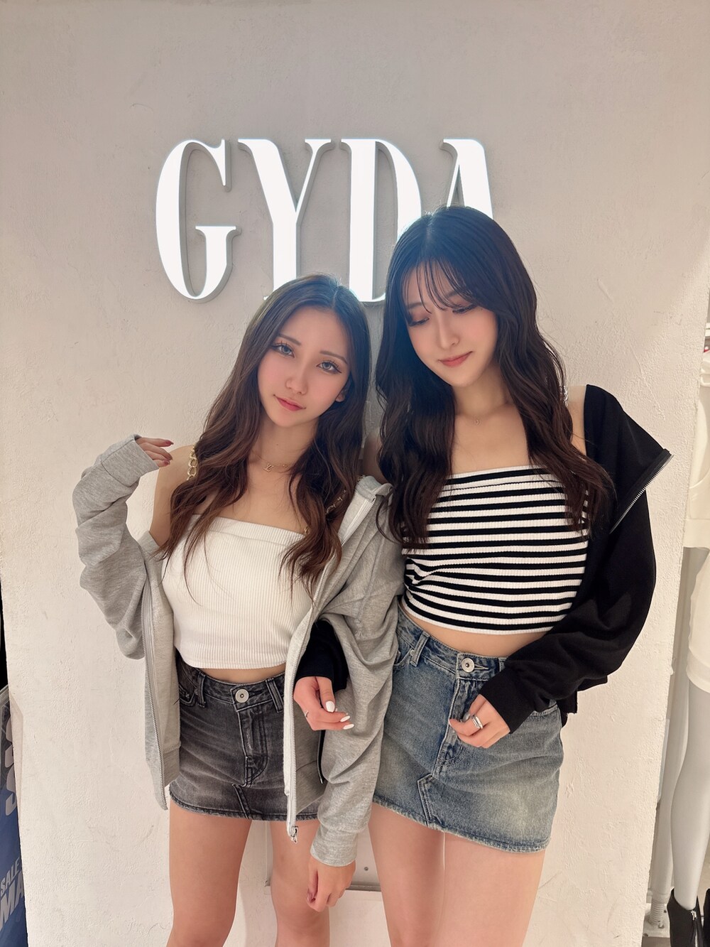 ブラック系のパーカー、ブルー系のデニムスカート、その他のキャミソールを着用したレディースの夏コーディネートの3枚目の写真