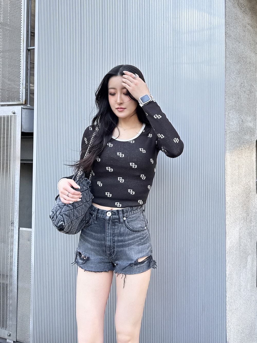 ブラック系のニット/セーター、ブラック系のデニムパンツ、ブラック系のブーツを着用したレディースの冬コーディネートの2枚目の写真