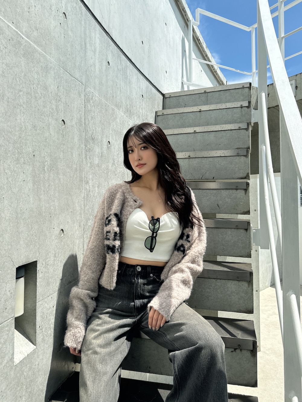 ブラック系のデニムパンツ、ブラック系のスリッポン、ベージュ系のカーディガン/ボレロを着用したレディースの秋コーディネートの3枚目の写真