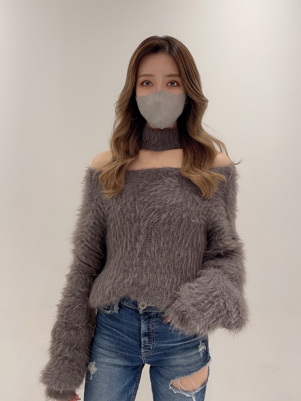 ブルー系のデニムパンツ、グレー系のニット/セーター、ブラック系のブーツを着用したレディースの冬コーディネートの3枚目の写真