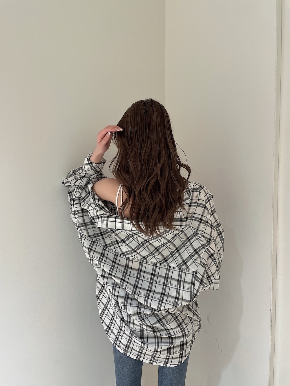 ブルー系のデニムパンツ、ホワイト系のシャツ/ブラウス、ホワイト系のキャミソールを着用したレディースの春コーディネートの4枚目の写真