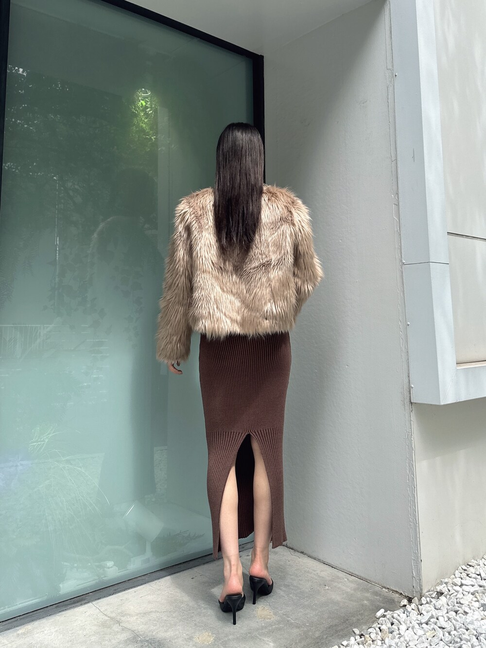 ベージュ系のライダースジャケット、ブラウン系のワンピース、ブラック系のパンプスを着用したレディースの秋コーディネートの2枚目の写真