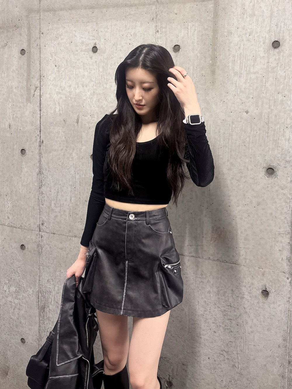 ブラック系のスカート、ブラック系のブーツ、ブラック系のブルゾンを着用したレディースの秋コーディネートの4枚目の写真