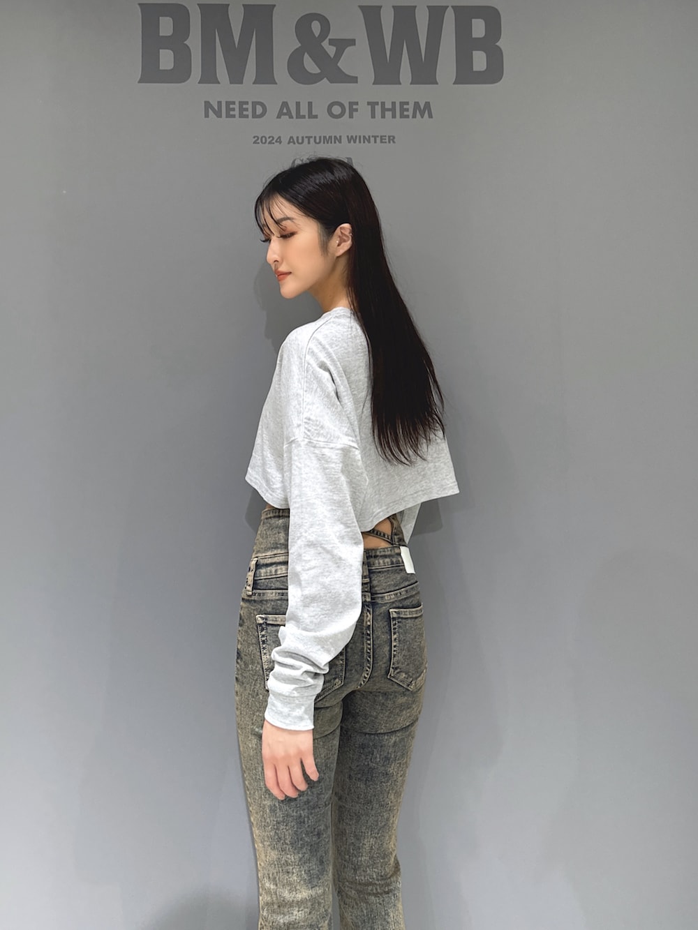 グレー系のTシャツ/カットソー、ブルー系のデニムパンツ、ブラック系のブーツを着用したレディースの秋コーディネートの4枚目の写真