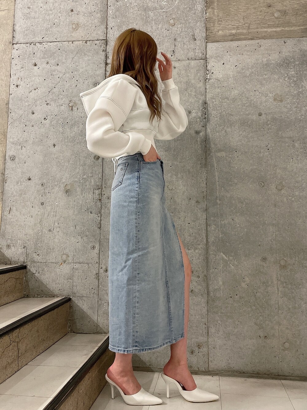 ホワイト系のパーカー、ブルー系のデニムスカート、ホワイト系のパンプスを着用したレディースの冬コーディネートの4枚目の写真