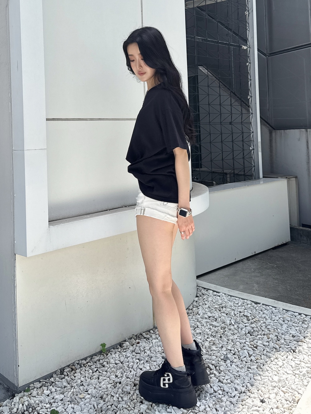 ブラック系のTシャツ/カットソー、ホワイト系のデニムパンツ、ブラック系のスニーカーを着用したレディースの夏コーディネートの5枚目の写真