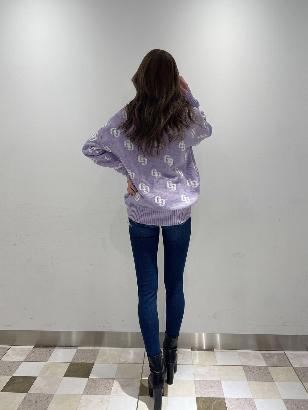 パープル系のニット/セーター、ブルー系のデニムパンツ、ブラック系のブーツを着用したレディースの冬コーディネートの3枚目の写真