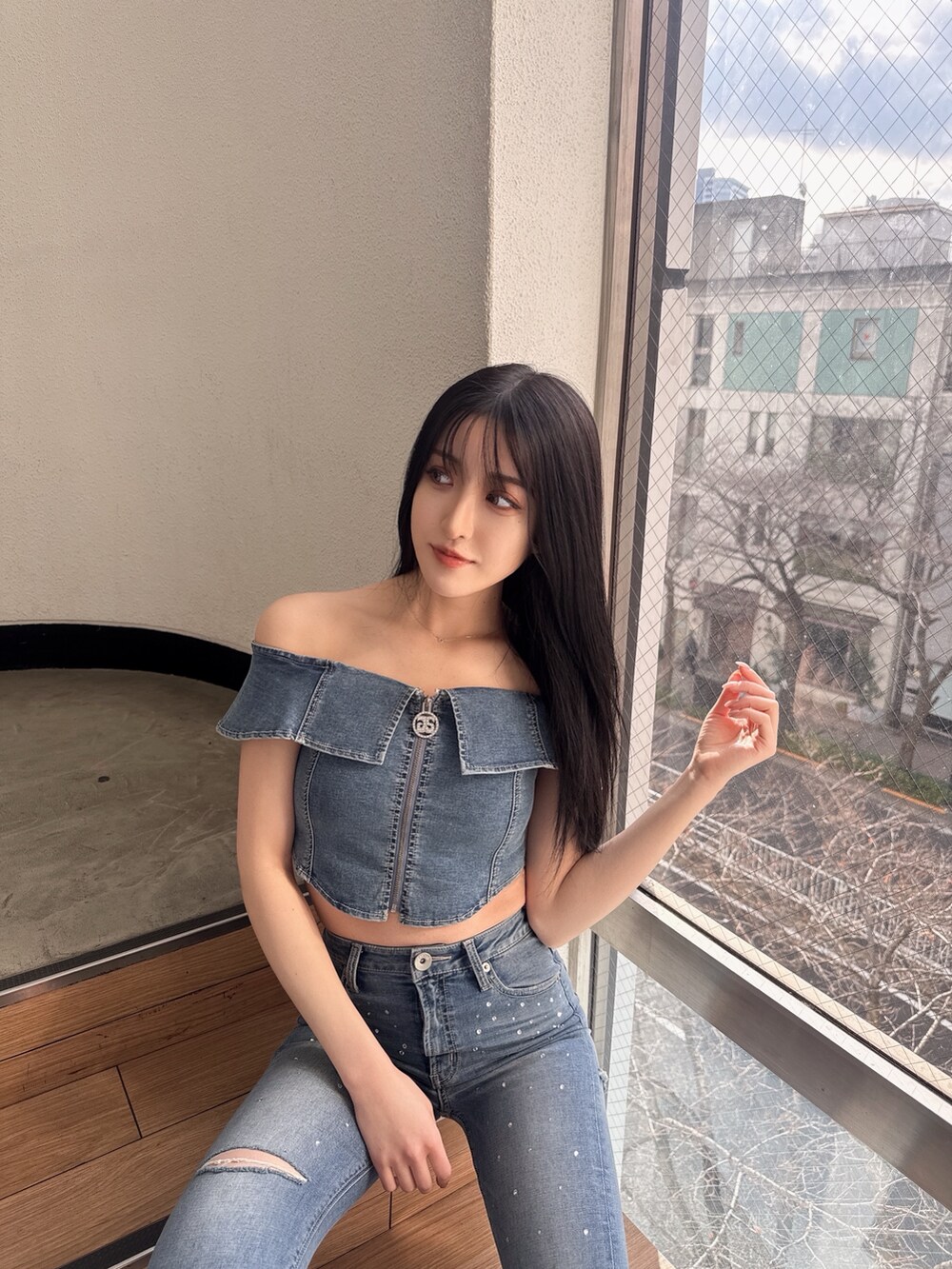 ブルー系のデニムパンツ、ブルー系のTシャツ/カットソー、ホワイト系のパンプスを着用したレディースの冬コーディネートの2枚目の写真