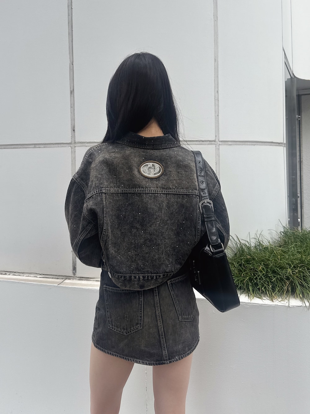 ブラック系のハンドバッグ、ブルー系のデニムジャケット、ブルー系のデニムスカートを着用したレディースの秋コーディネートの2枚目の写真