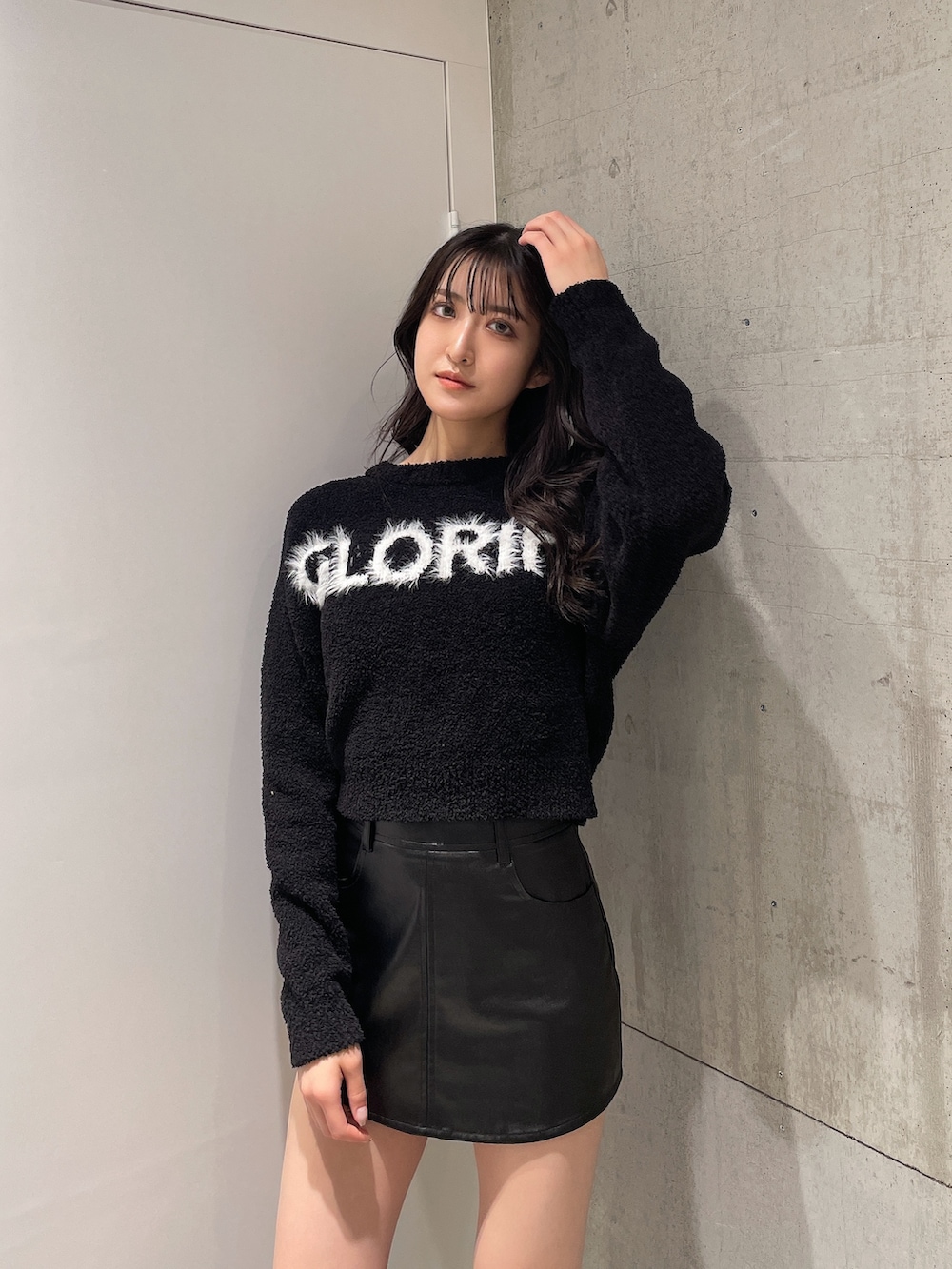 ブラック系のニット/セーター、ブラック系のスカート、ブラック系のブーツを着用したレディースの秋コーディネートの2枚目の写真