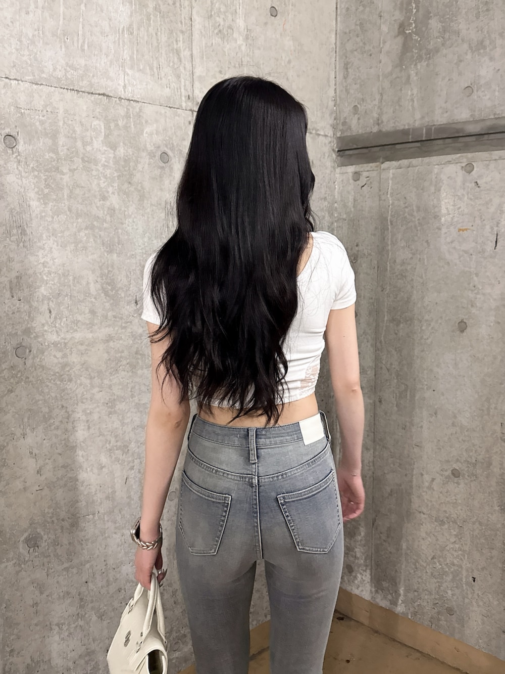 ホワイト系のTシャツ/カットソー、ブルー系のデニムパンツ、ホワイト系のサンダルを着用したレディースの夏コーディネートの4枚目の写真