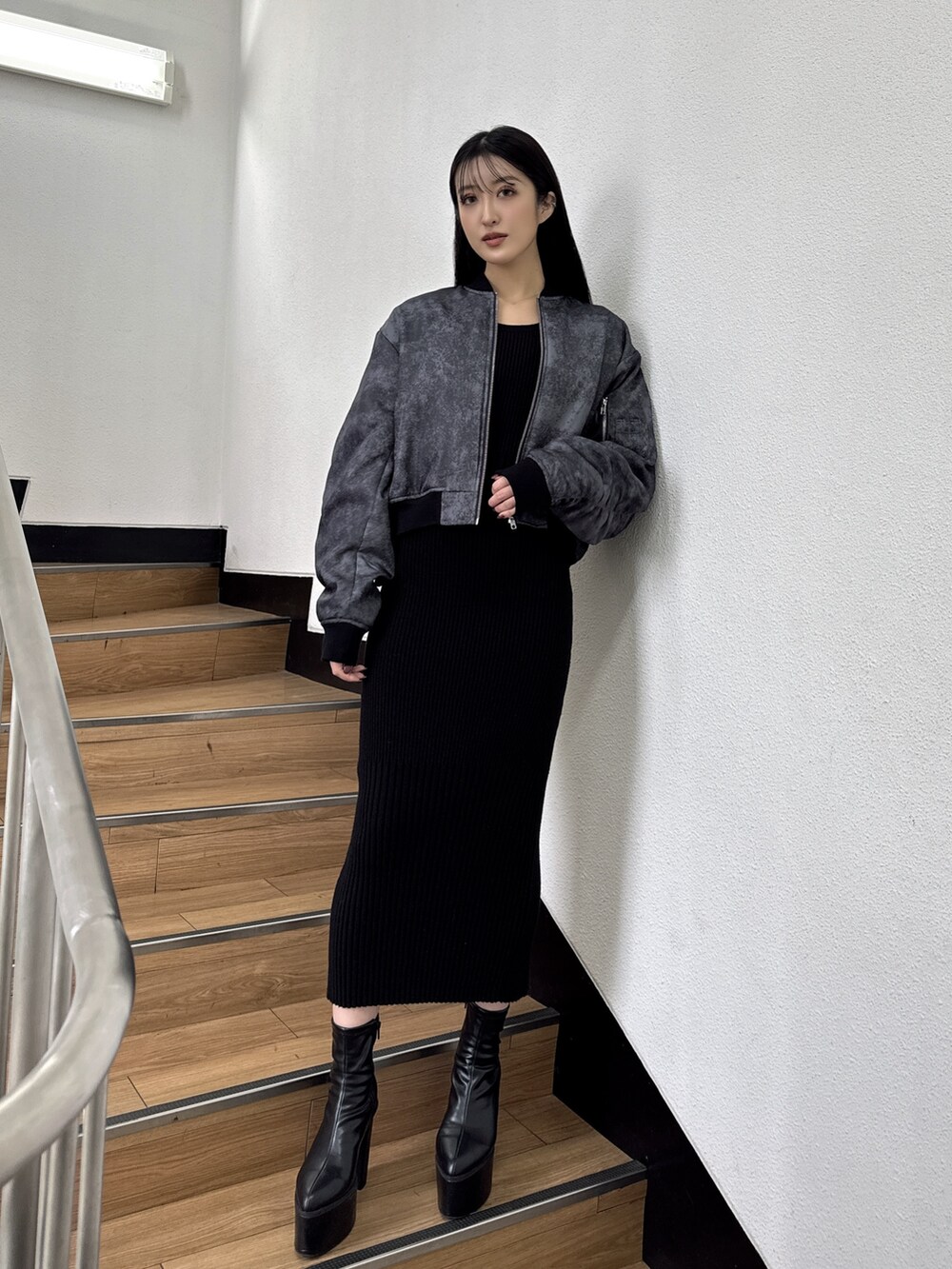 ブラック系のMA-1、ブラック系のワンピース、ブラック系のブーツを着用したレディースの秋コーディネートの2枚目の写真