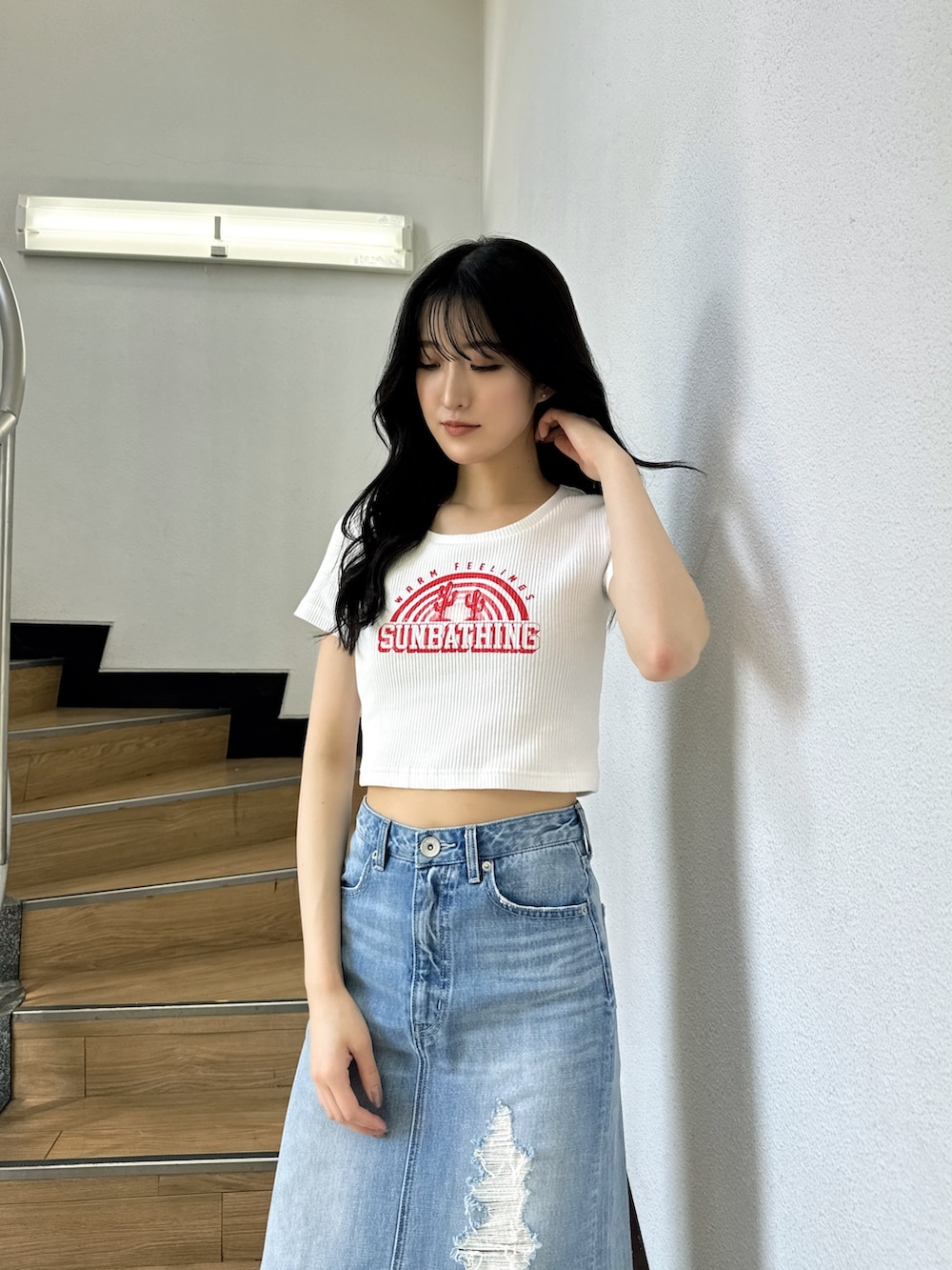 ホワイト系のTシャツ/カットソー、ブルー系のデニムスカート、ホワイト系のサンダルを着用したレディースの夏コーディネートの3枚目の写真