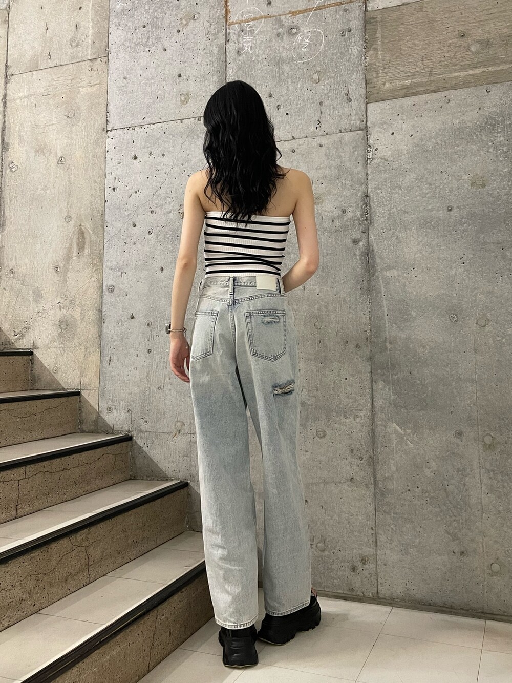 その他のチューブトップ、ブルー系のデニムパンツ、ブラック系のサンダルを着用したレディースの春コーディネートの3枚目の写真