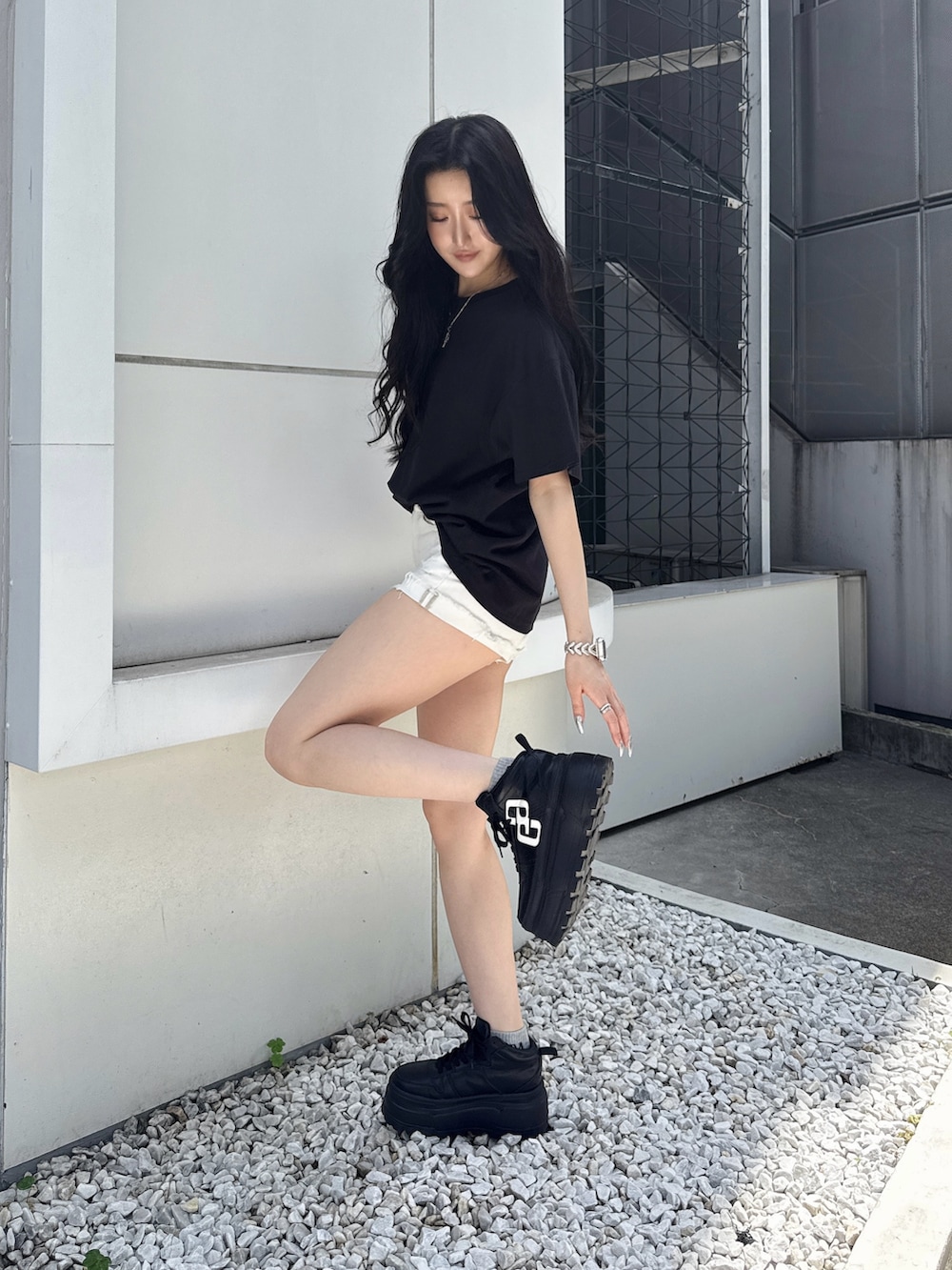 ブラック系のTシャツ/カットソー、ホワイト系のデニムパンツ、ブラック系のスニーカーを着用したレディースの夏コーディネートの2枚目の写真