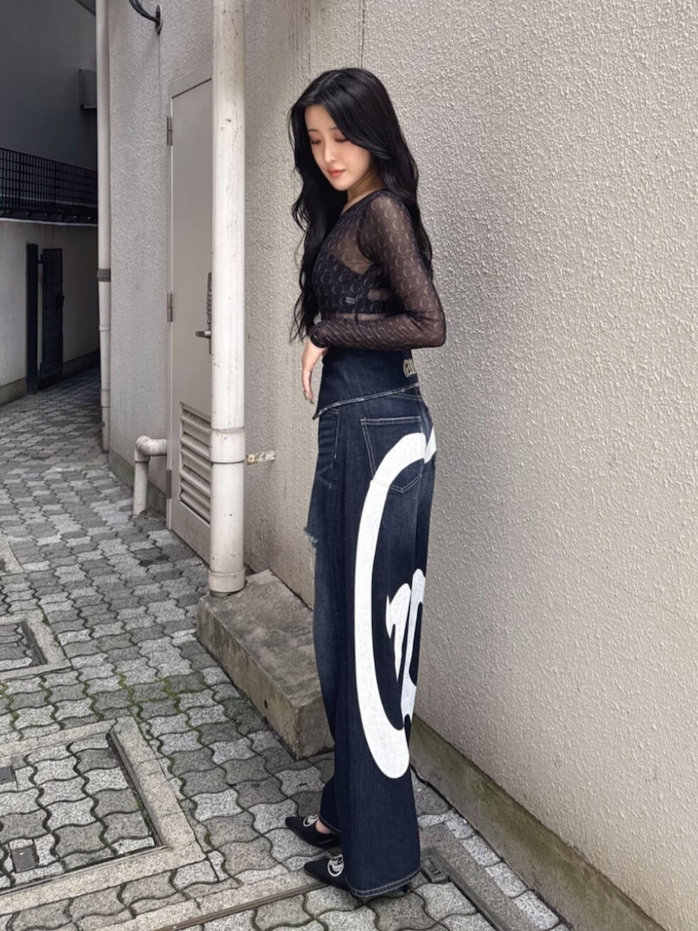 ブラック系のTシャツ/カットソー、ブルー系のデニムパンツ、ブラック系のパンプスを着用したレディースの夏コーディネートの2枚目の写真