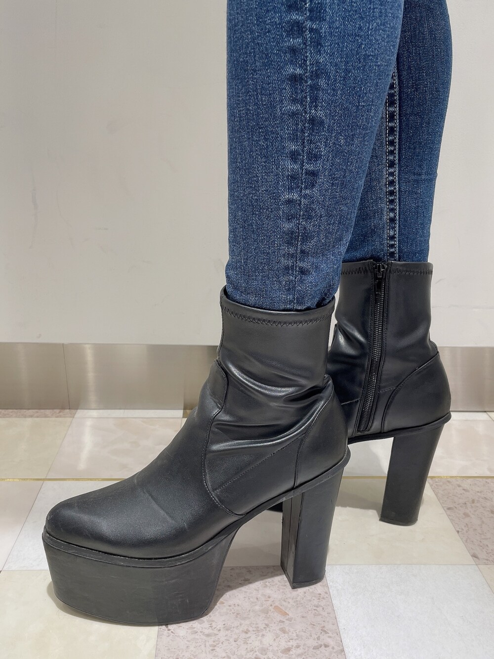 ブルー系のデニムパンツ、グレー系のニット/セーター、ブラック系のブーツを着用したレディースの冬コーディネートの7枚目の写真
