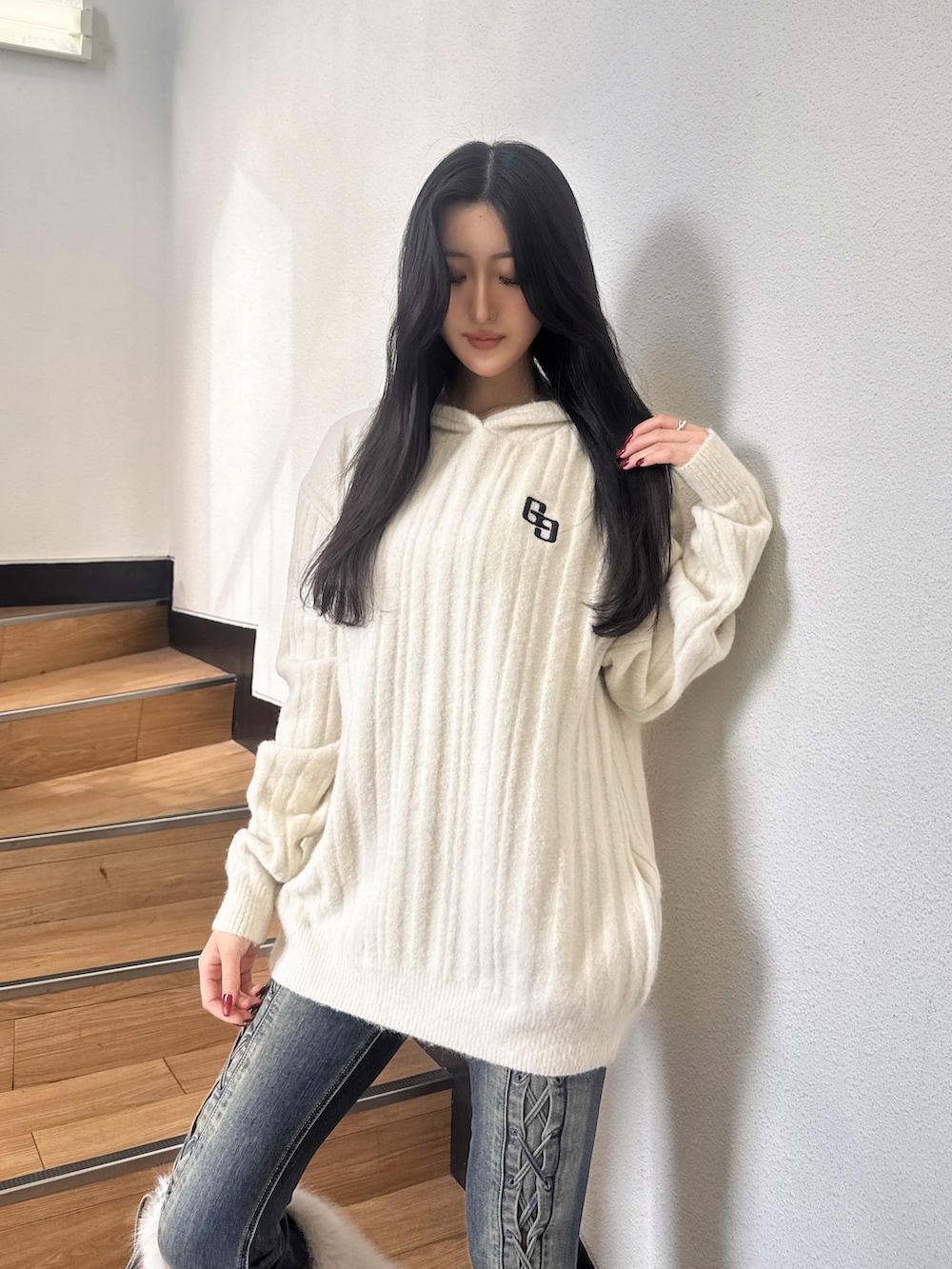 ホワイト系のワンピース、ブルー系のデニムパンツ、ブラック系のブーツを着用したレディースの秋コーディネートの3枚目の写真