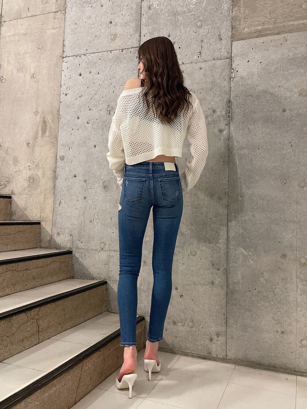 ホワイト系のキャミソール、ホワイト系のニット/セーター、ホワイト系のパンプスを着用したレディースの春コーディネートの3枚目の写真