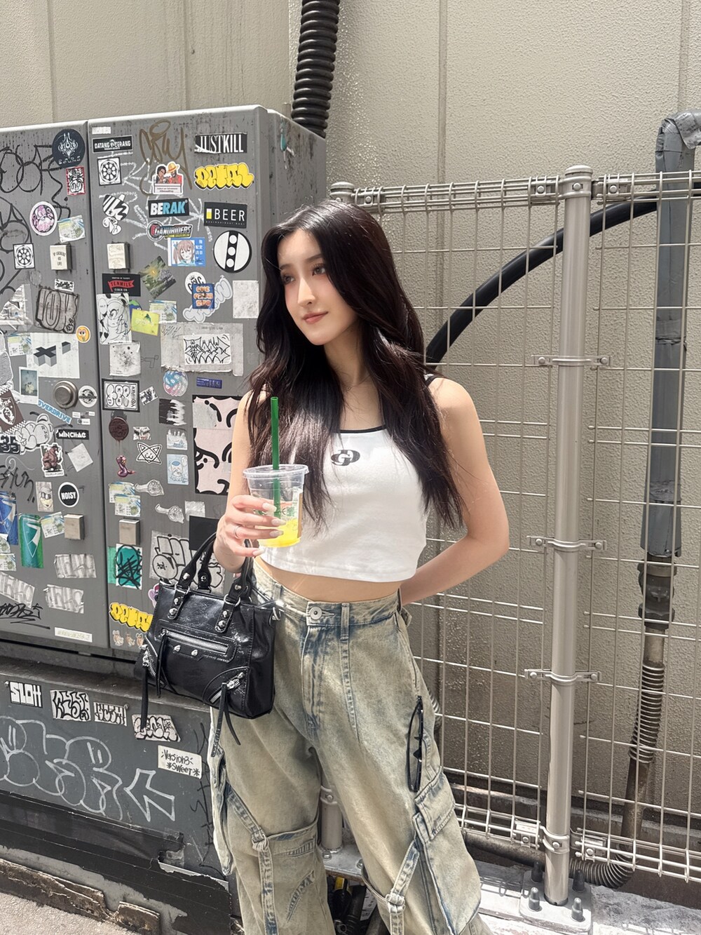 ホワイト系のキャミソール、ブルー系のデニムパンツ、ブラック系のサンダルを着用したレディースの夏コーディネートの6枚目の写真