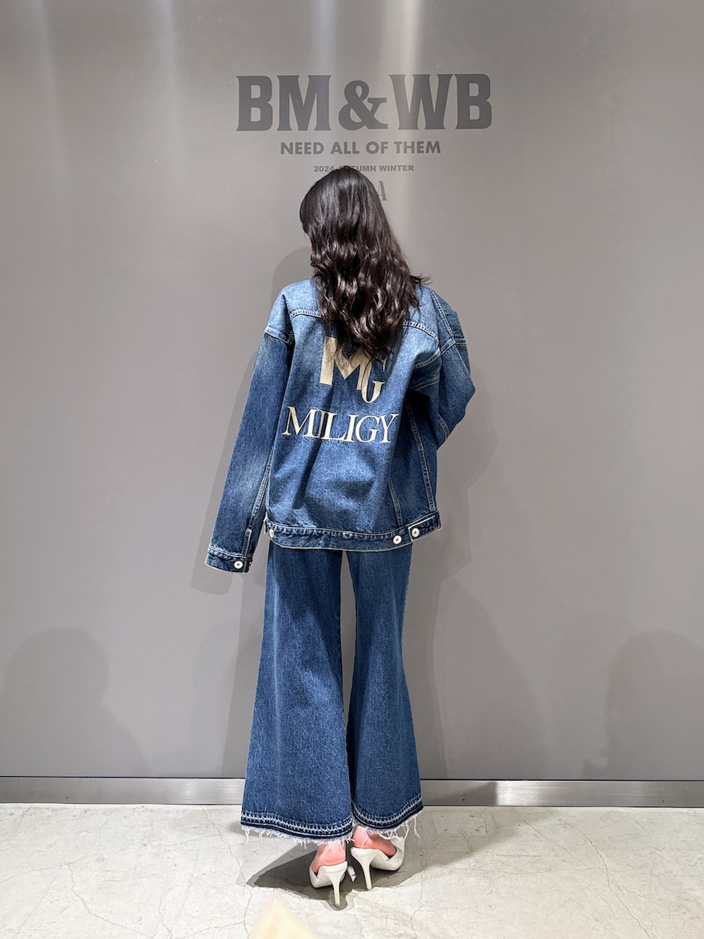 ブルー系のデニムジャケット、ブルー系のデニムパンツ、ホワイト系のパンプスを着用したレディースの秋コーディネートの2枚目の写真