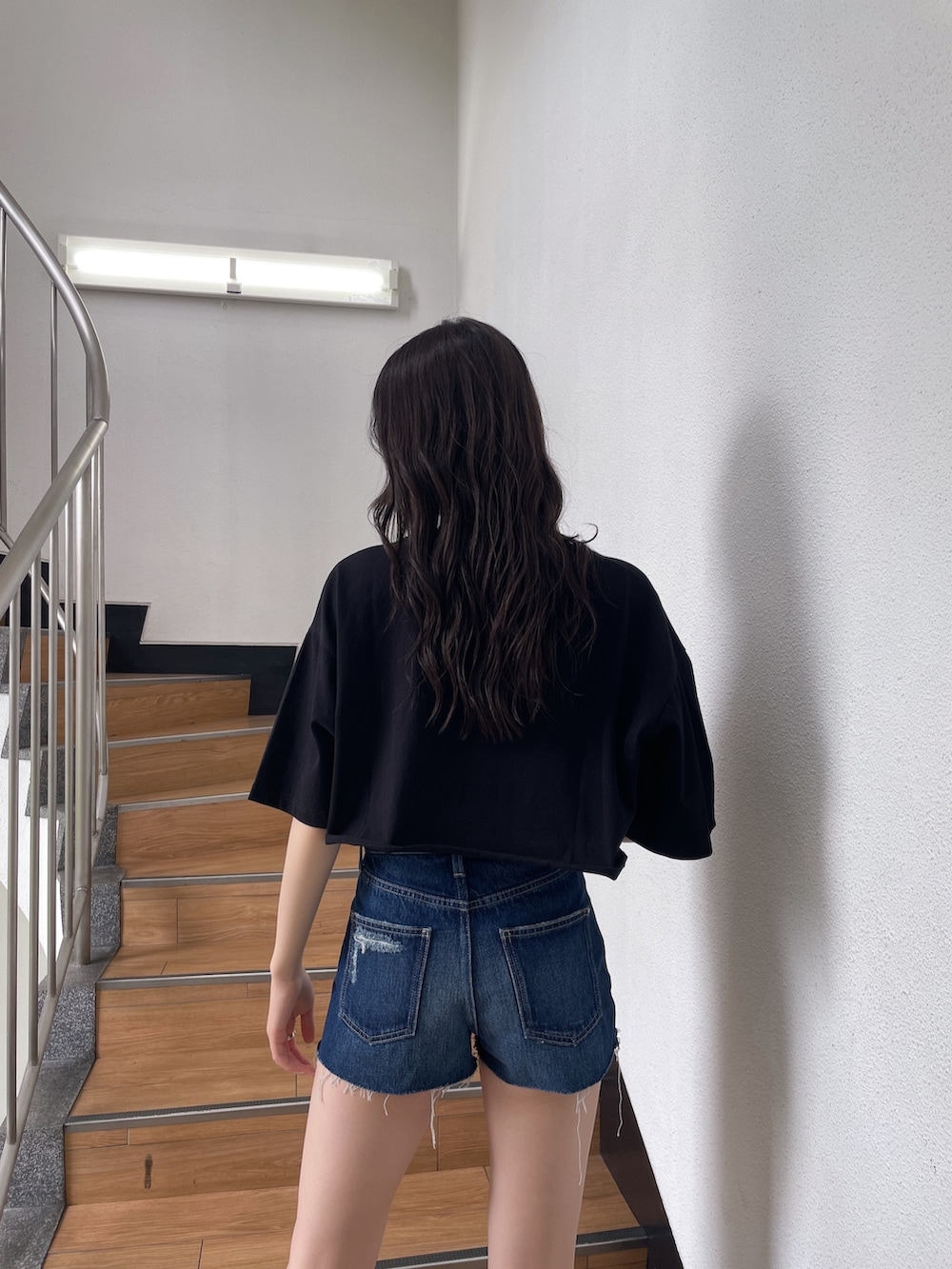 ブラック系のTシャツ/カットソー、ブルー系のデニムパンツ、ブラック系のサンダルを着用したレディースの春コーディネートの4枚目の写真