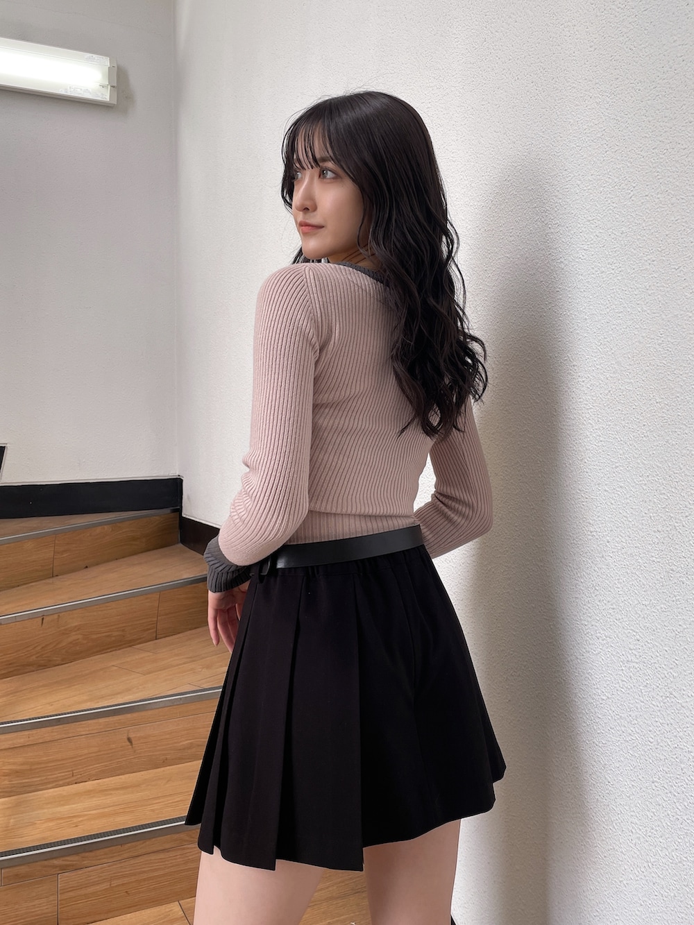 ピンク系のニット/セーター、ブラック系のスカート、ブラック系のブーツを着用したレディースの秋コーディネートの5枚目の写真