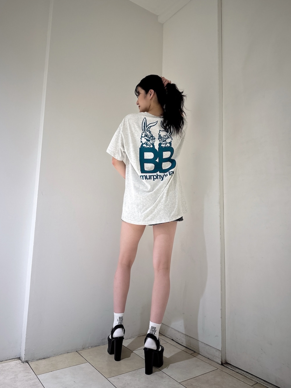 グレー系のTシャツ/カットソー、ブラック系のデニムスカート、ブラック系のサンダルを着用したレディースの夏コーディネートの2枚目の写真