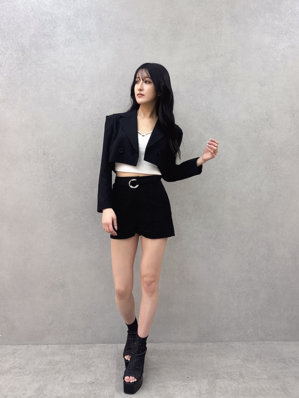 ブラック系のテーラードジャケット、ブラック系のその他パンツ、ホワイト系のキャミソールを着用したレディースの冬コーディネートの3枚目の写真