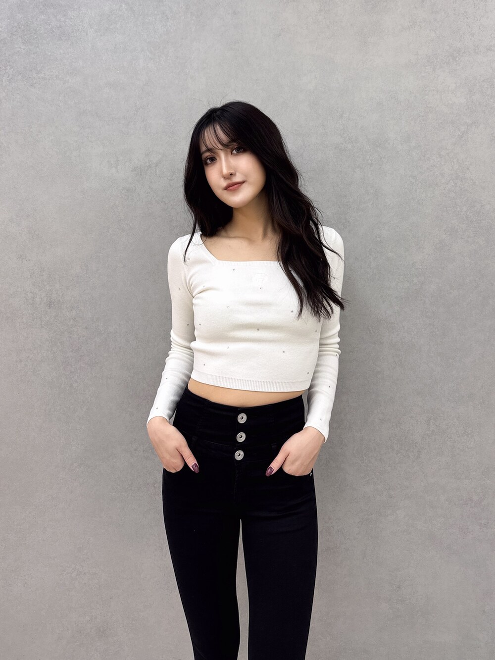 ホワイト系のニット/セーター、ブラック系のデニムパンツ、ホワイト系のパンプスを着用したレディースの冬コーディネートの3枚目の写真