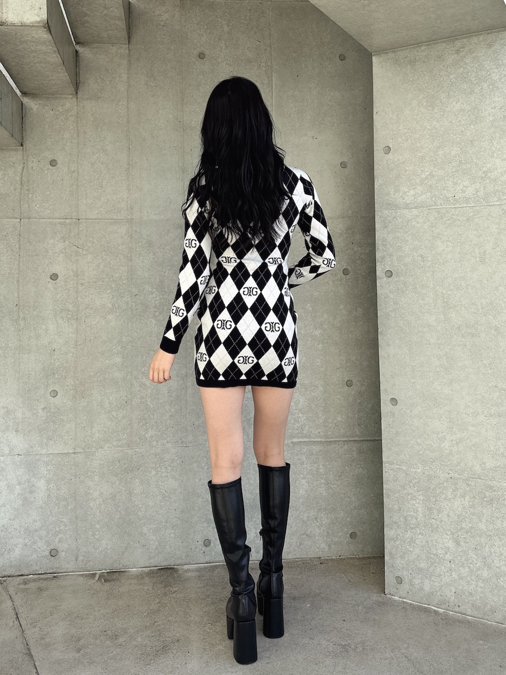 ブラック系のワンピース、ブラック系のブーツを着用したレディースの冬コーディネートの2枚目の写真