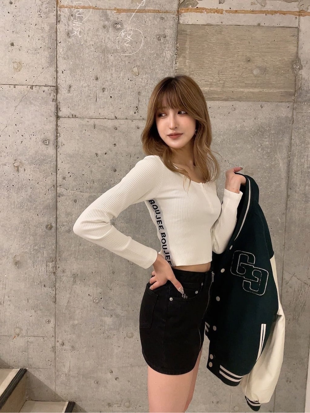 グリーン系のスタジャン、グリーン系のスタジャン、ブラック系のブーツを着用したレディースの秋コーディネートの3枚目の写真