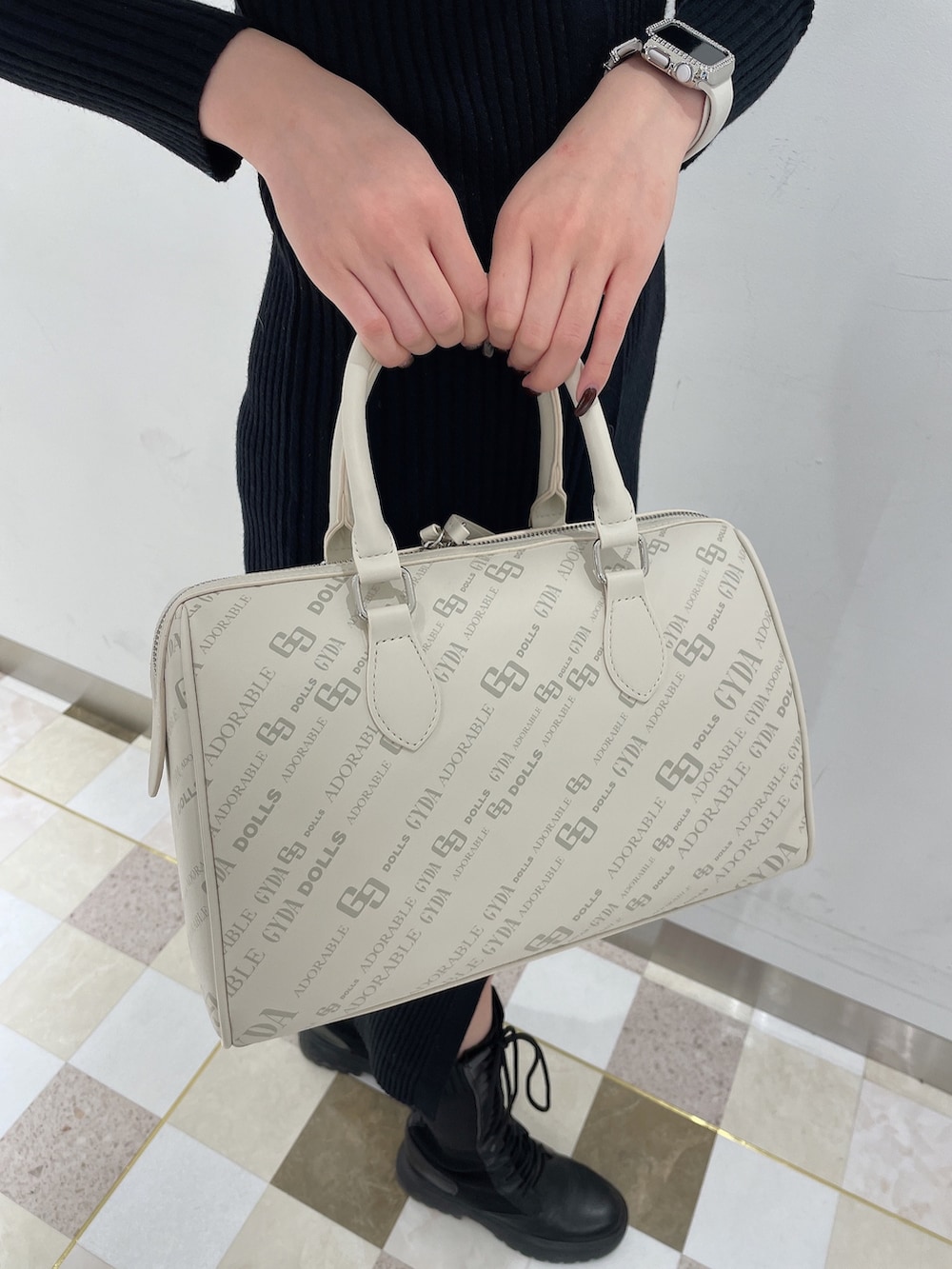 ブラック系のワンピース、ブラック系のブーツ、ホワイト系のボストンバッグを着用したレディースの秋コーディネートの6枚目の写真