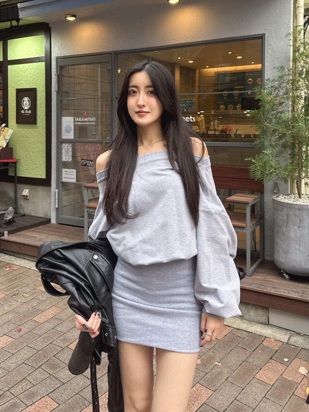 グレー系のワンピース、ブラック系のブーツを着用したレディースの冬コーディネートの2枚目の写真