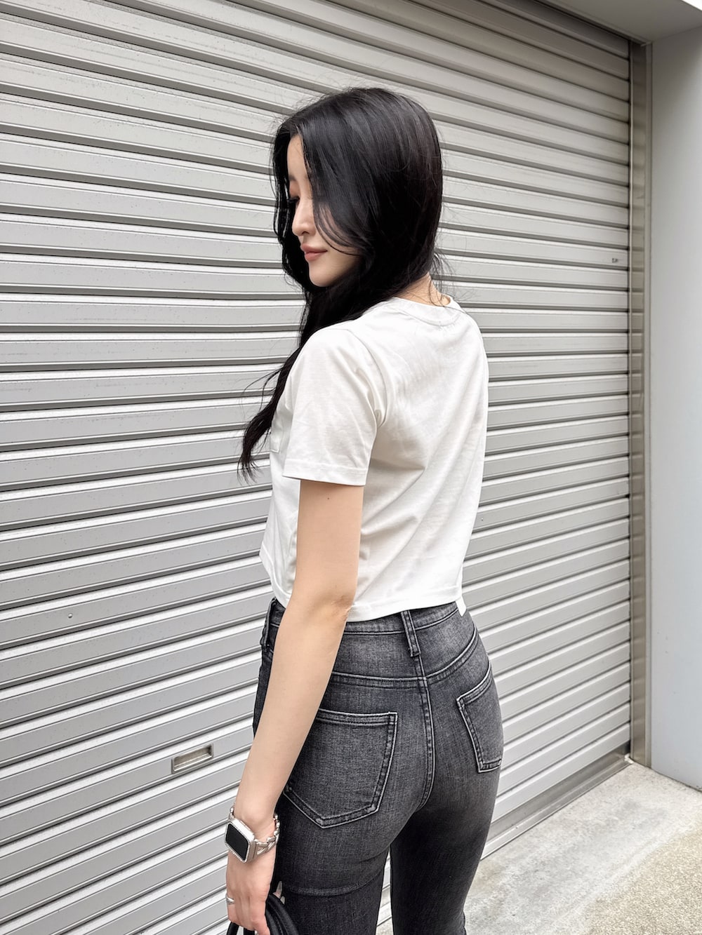 ホワイト系のTシャツ/カットソー、ブラック系のデニムパンツ、ブラック系のボストンバッグを着用したレディースの夏コーディネートの5枚目の写真
