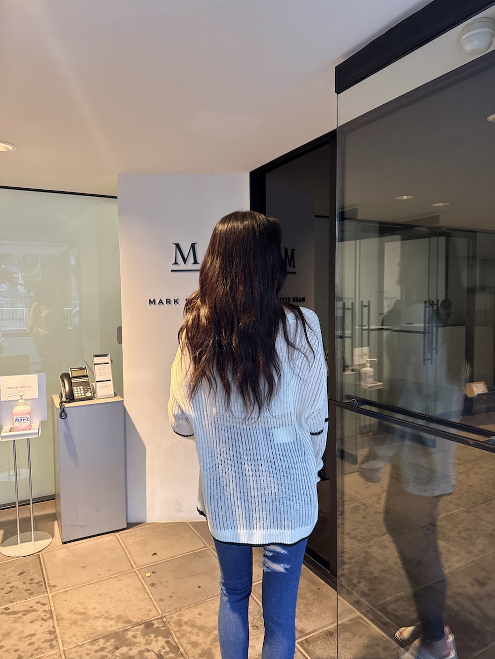 ブラック系のカーディガン/ボレロ、ホワイト系のキャミソール、ホワイト系のサンダルを着用したレディースの夏コーディネートの5枚目の写真