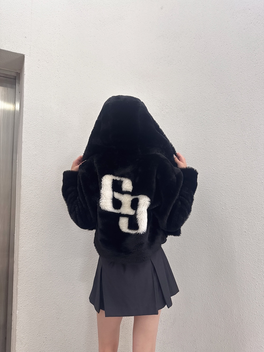 ブラック系のスカート、ブラック系のブーツ、ブラック系のニット/セーターを着用したレディースの秋コーディネートの3枚目の写真